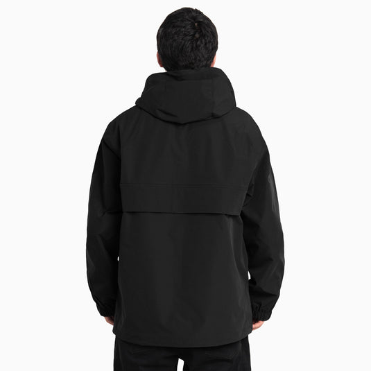 Back of a man in a black hooded pullover anorak jacket with a half-zip neckline.
