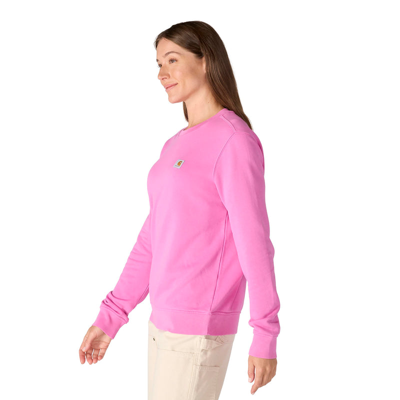 Load image into Gallery viewer, Woman wearing a pink fleece crewneck sweatshirt with a Carhartt woven logo on the left chest a white background
