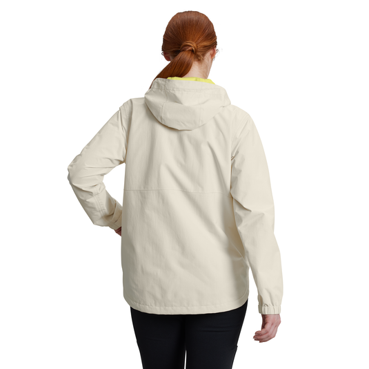 A woman with red hair tied back is shown from the back wearing a light cream hooded jacket and black pants against a plain white background.