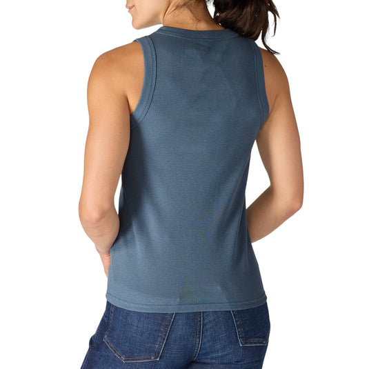 Woman wearing a blue sleeveless tank top and jeans on a white background