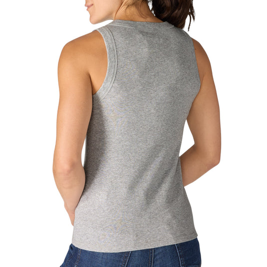 Woman wearing a heather gray tank top and blue jeans on a white background