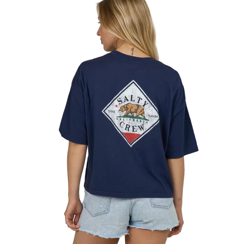 Load image into Gallery viewer, Woman wearing a navy blue cropped t-shirt with a Salty Crew screen printed logo with a California bear motif.
