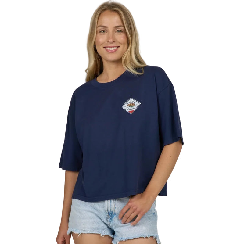Load image into Gallery viewer, Woman wearing a navy blue cropped t-shirt with a Salty Crew screen printed logo with a California bear motif.
