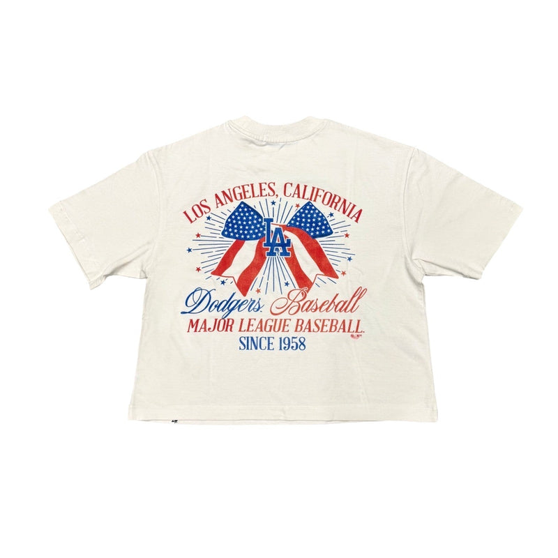 Load image into Gallery viewer, Back view of a women's relaxed fit '47 Brand Los Angeles Dodgers crop top featuring a patriotic red, white, and blue USA bow graphic, fireworks, and vintage baseball-inspired artwork celebrating Los Angeles, California.
