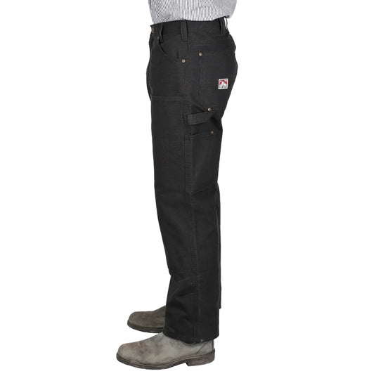 Black work pants worn by a person on a white background