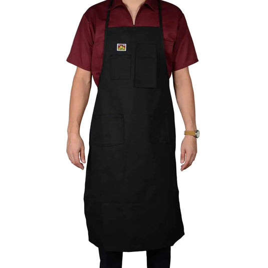 Person wearing a black apron over a maroon shirt on a white background