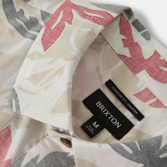 Off white short sleeve button up shirt with faded black and faded red floral print pattern. Brixton woven label inside under collar