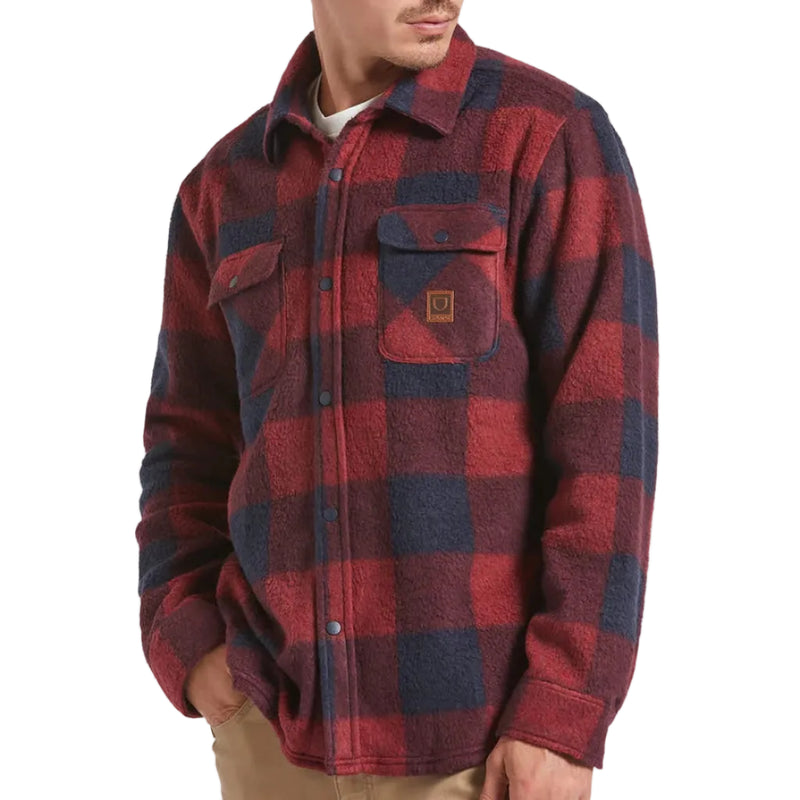 Load image into Gallery viewer, Person wearing a red and blue plaid fleece shirt with a visible Brixton brand logo patch on the left chest pocket on a white background
