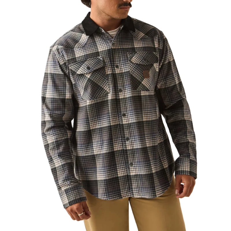 Load image into Gallery viewer, A man wearing a black and gray plaid button-up flannel shirt, tan pants, and a black baseball cap with a logo patch, standing against a plain white background.
