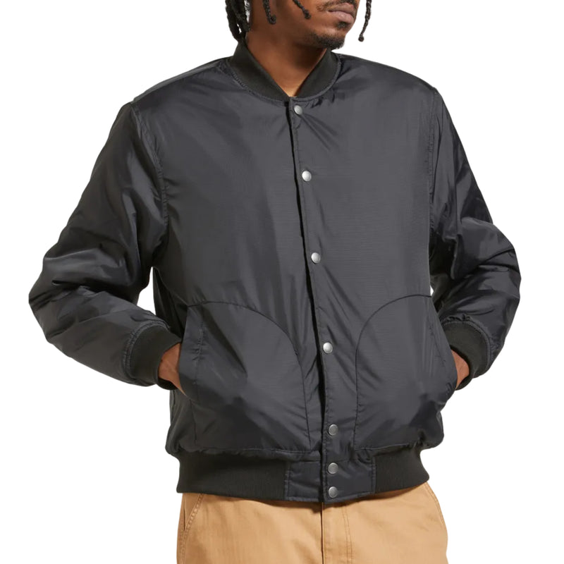 Load image into Gallery viewer, A man wearing a black bomber jacket with silver snap buttons and tan cargo pants, shown from the waist up against a plain white background.
