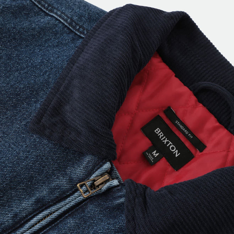 Load image into Gallery viewer, Close-up of a blue denim jacket with a dark navy corduroy collar, showing a red interior lining and a black Brixton brand label.
