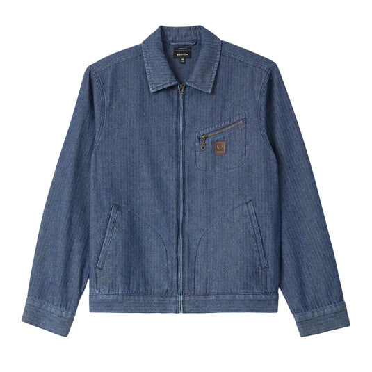 A blue denim jacket with a zippered front, pointed collar, and a small brown leather Brixton logo patch on the chest pocket, displayed flat against a white background.