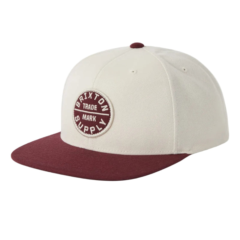 Load image into Gallery viewer, Off white Brixton snapback with a maroon red visor and embroidered Brixton logo on the front
