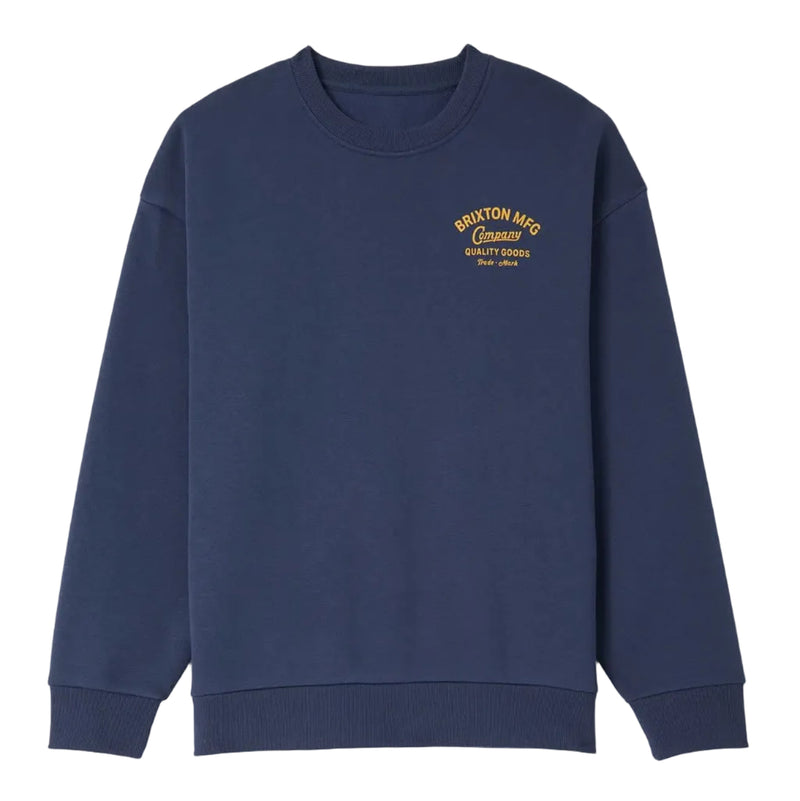 Load image into Gallery viewer, A navy blue crewneck sweatshirt with a small yellow screenprinted graphic on the left chest reading 'BRIXTON MFG' and 'Company' below it, displayed against a white background.
