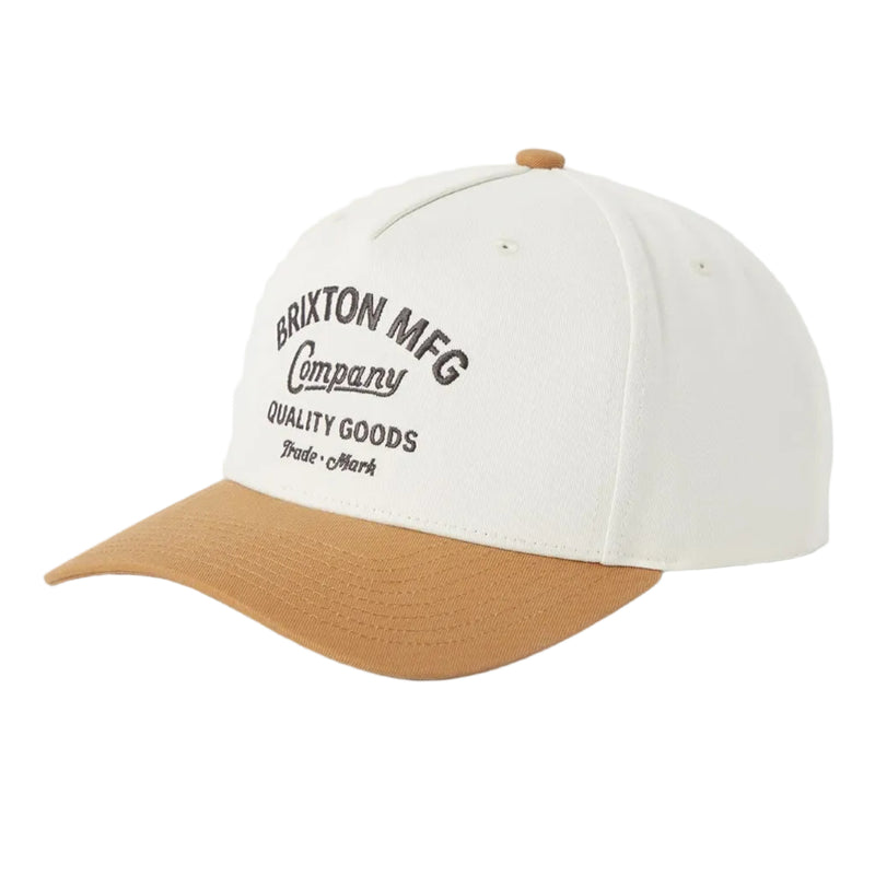 Load image into Gallery viewer, A baseball cap with an off-white crown and a tan curved brim, featuring black embroidered text on the front that reads 'BRIXTON MFG Company QUALITY GOODS'.
