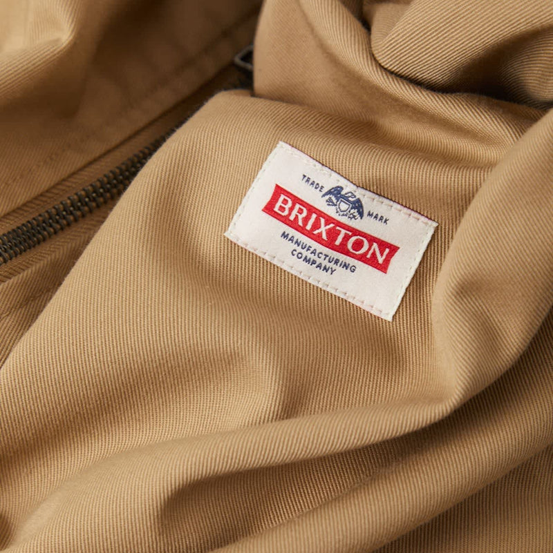 Load image into Gallery viewer, Closeup of the Brixton Trademark patch on the Khaki Brixton Garage zipper jacket
