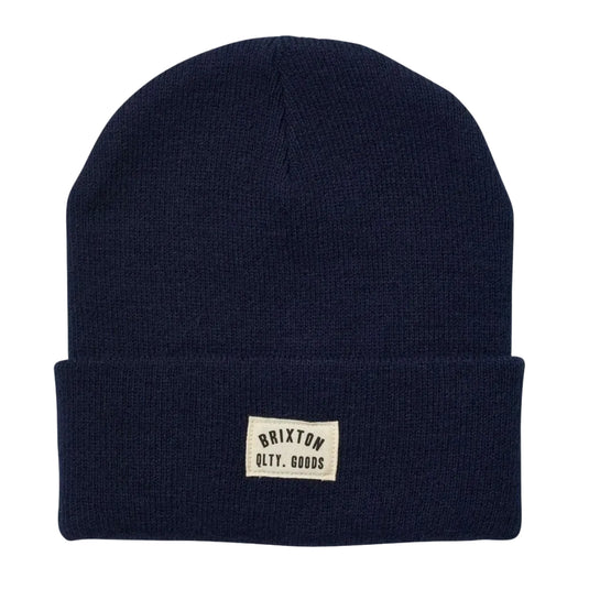 Navy blue beanie with a small logo on a light gray background