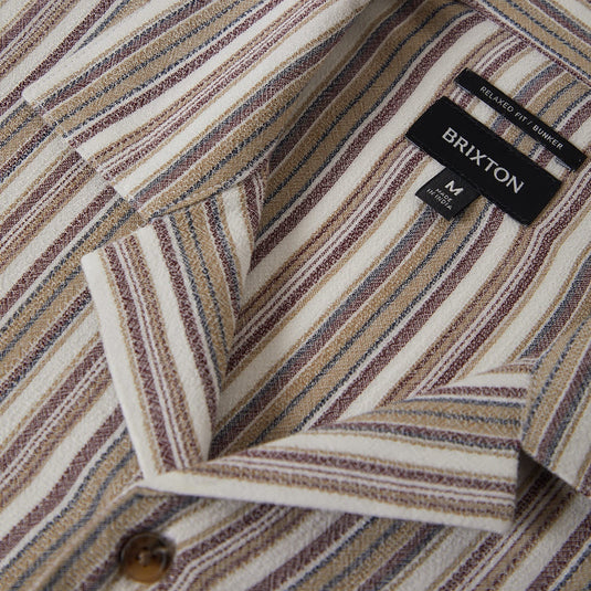 Close-up of the collar of a striped button up shirt with a Brixton label
