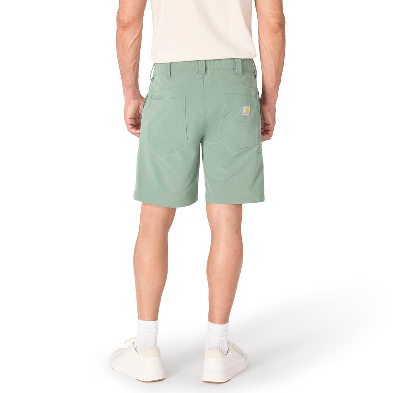 Load image into Gallery viewer, Person wearing 8" inseam green slate colored shorts with two back pockets and the Carhartt patch logo on the right back pocket on a white background
