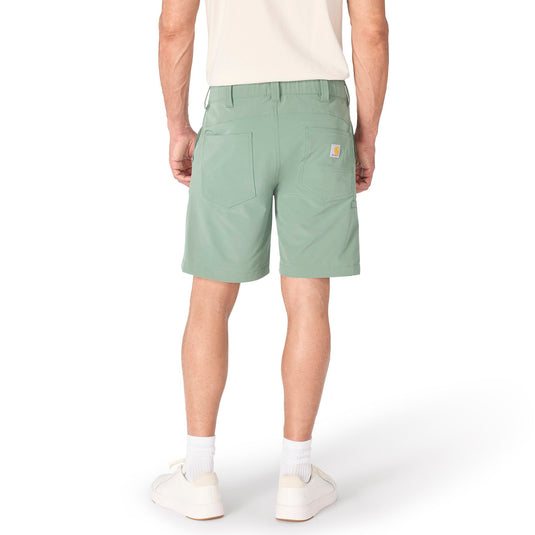 Person wearing 8" inseam green slate colored shorts with two back pockets and the Carhartt patch logo on the right back pocket on a white background