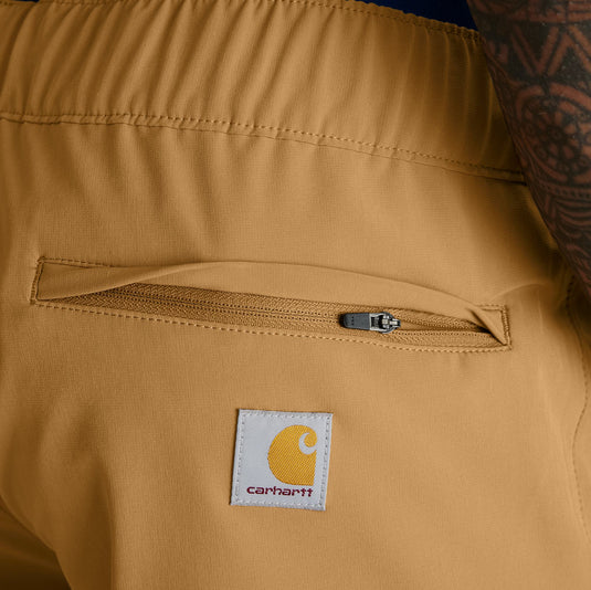 Close-up of a brown shorts with a Carhartt logo on a person wearing it.