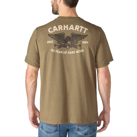 A man wearing a brown Carhartt t-shirt, viewed from the back. The shirt features a large distressed graphic on the back with the Carhartt brand name, an eagle emblem, and the text 'SINCE 1869' and 'NO FEAR OF HARD WORK'.