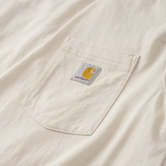 Close-up of a cream-colored Carhartt pocket with the brand's signature yellow logo patch on the chest.