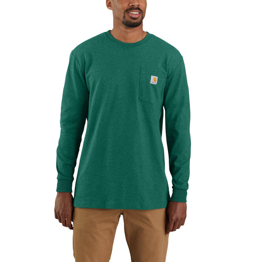 Person wearing a long sleeve heather green Carhartt pocket tee with the Carhartt logo sewn onto the chest pocket. 
