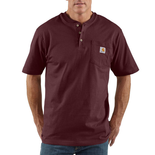 Person wearing a dark burgundy short sleeve henley pocket tee with the Carhartt logo sewn on the chest pocket.