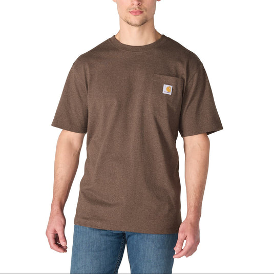 A man wearing a brown short-sleeve pocket t-shirt with a small Carhartt logo patch on the chest, paired with blue jeans, against a plain white background.