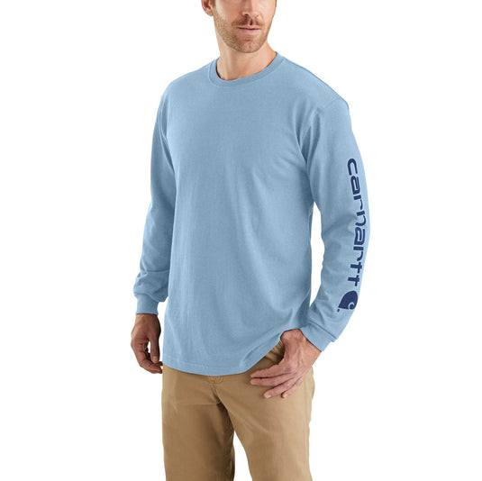 Man wearing a light blue long-sleeve shirt with a Carhartt logo on a white background