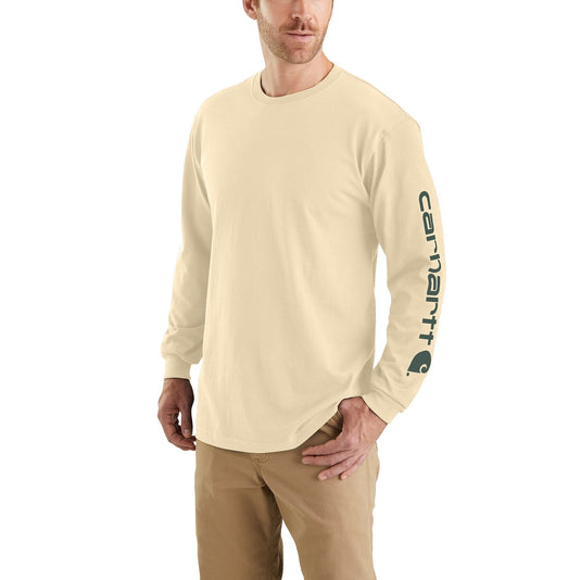 Man wearing oat milk colored long sleeve shirt with carhartt logo along the left arm sleeve on a white background