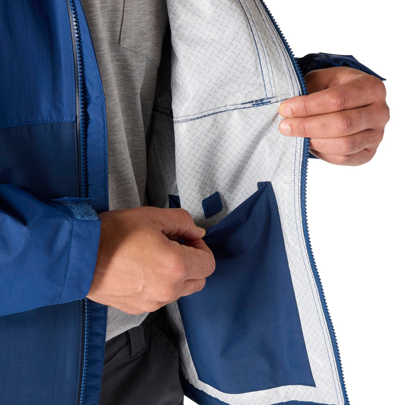 Load image into Gallery viewer, Close-up of a person wearing a blue and gray waterproof jacket, opening the front zipper to show the light gray patterned interior lining and a blue pocket.
