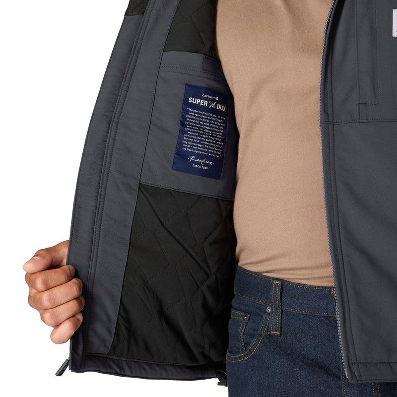 Load image into Gallery viewer, Close-up of a person wearing a dark slate gray zip-up jacket, holding the left side open to show the black quilted interior lining and a blue interior label that reads 'SUPER DUX'. The person is also wearing a tan crewneck shirt and blue jeans.
