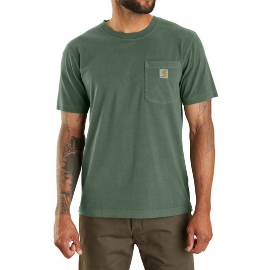Man wearing a green t-shirt with a Carhartt brand logo on the left chest pocket on a white background