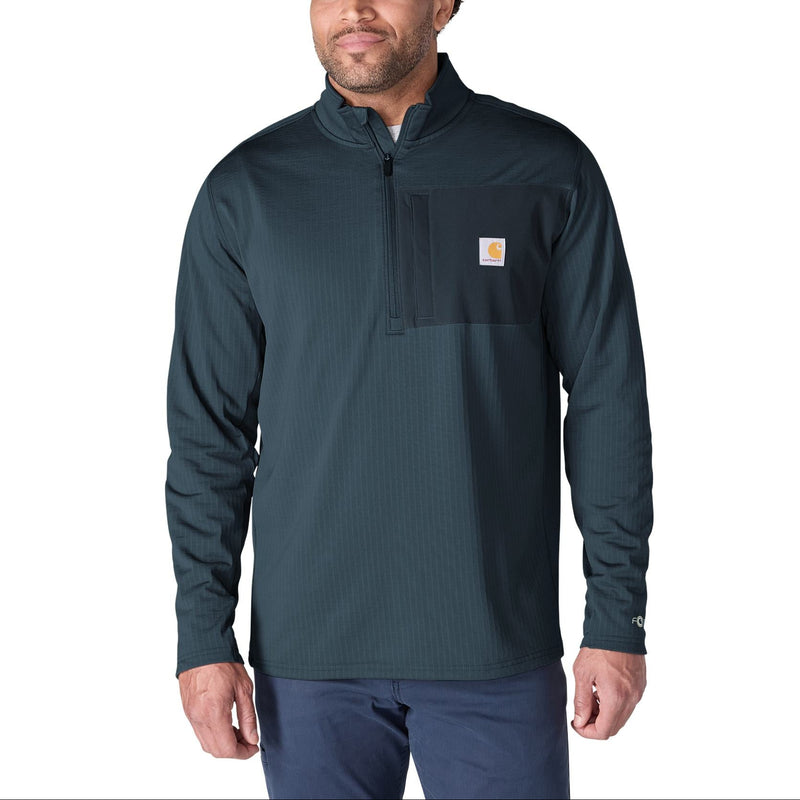 Load image into Gallery viewer, A man wearing a dark teal Carhartt quarter-zip pullover with a chest pocket and the signature Carhartt logo patch, paired with navy pants, against a solid white background.
