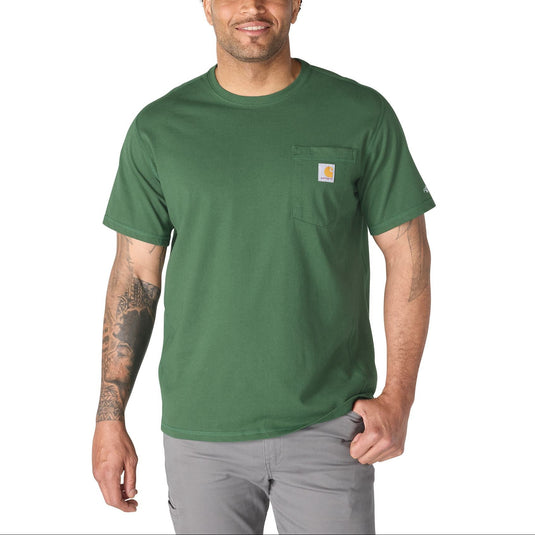 A man wearing a green short-sleeve pocket t-shirt by Carhartt, paired with gray pants, standing against a plain white background.