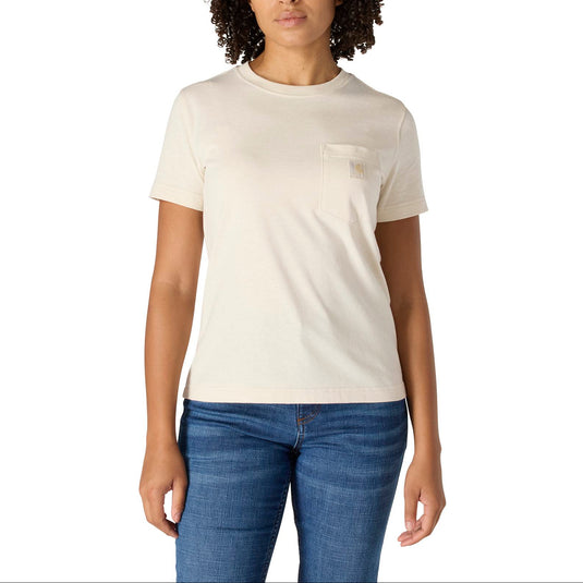 A woman with curly dark hair wearing a cream-colored short-sleeve crewneck t-shirt with a small chest pocket and blue jeans, standing against a solid white background.