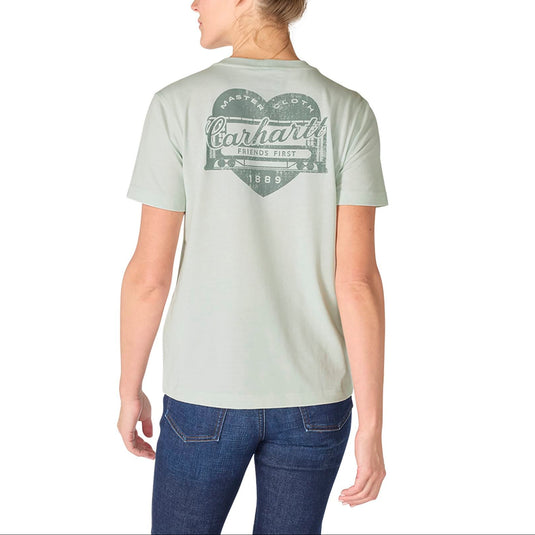 Person wearing a light green t-shirt with a brand logo on the back, standing against a white background