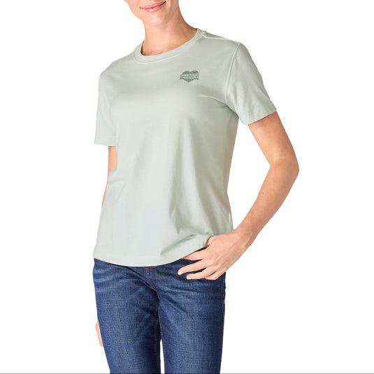 Woman wearing a light green t-shirt with a carhartt heart logo on a white background