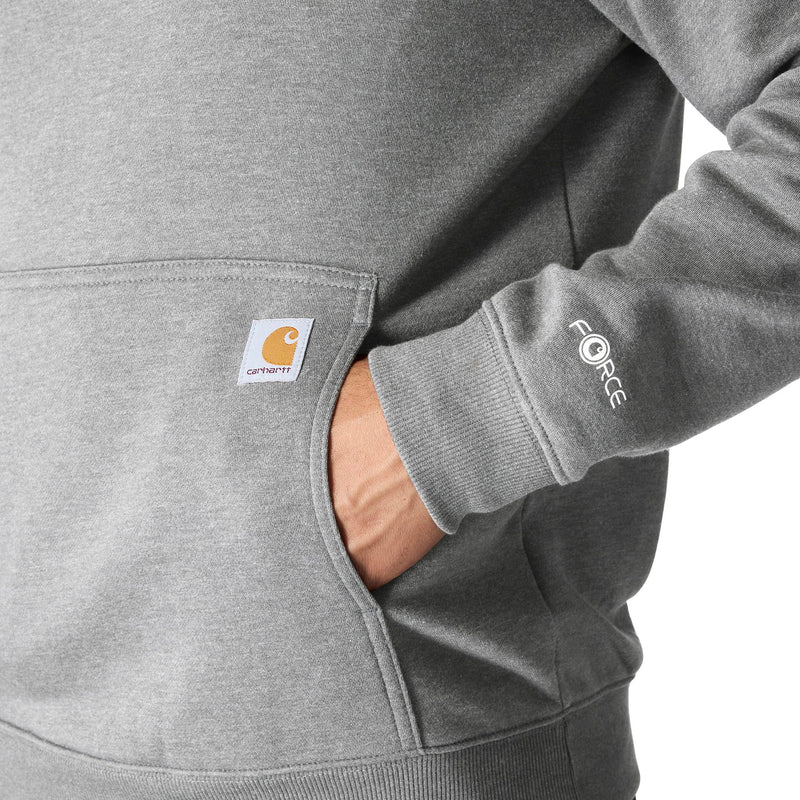 Load image into Gallery viewer, Close-up of a person wearing a heather gray Carhartt hoodie, showing the front pocket with the Carhartt logo patch and the right sleeve with white 'FORCE' text.
