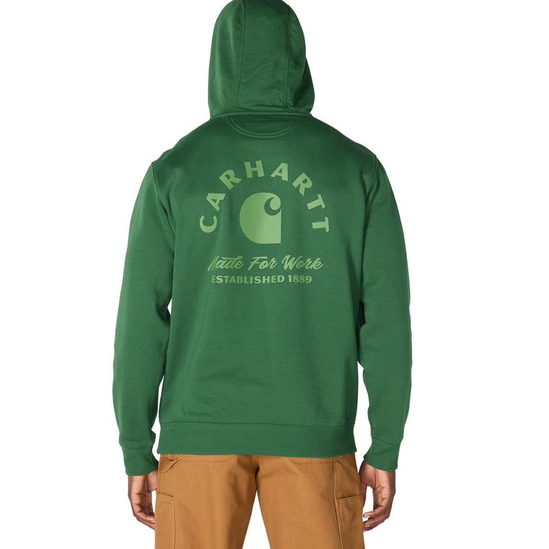 Load image into Gallery viewer, A person shown from the back wearing a green Carhartt hoodie with a light green Carhartt logo and text printed on the back, paired with tan pants, against a plain white background.
