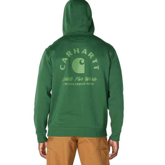 A person shown from the back wearing a green Carhartt hoodie with a light green Carhartt logo and text printed on the back, paired with tan pants, against a plain white background.
