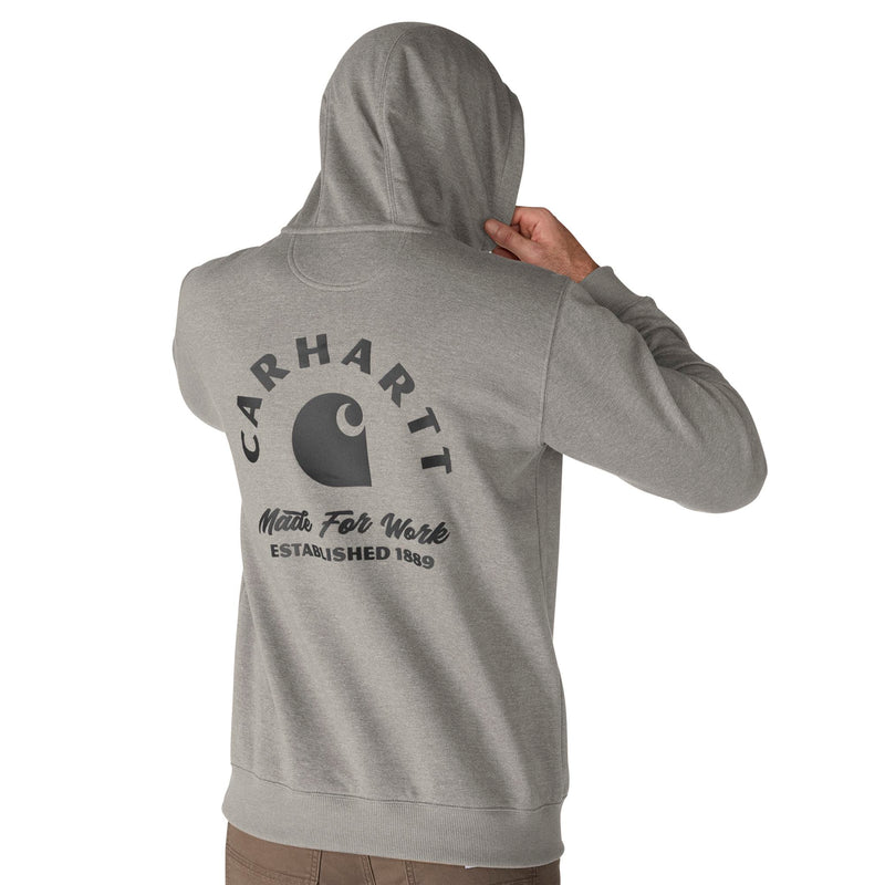 Load image into Gallery viewer, A person shown from the back wearing a heather gray Carhartt hoodie with a large dark gray Carhartt logo and text printed on the back, against a plain white background.
