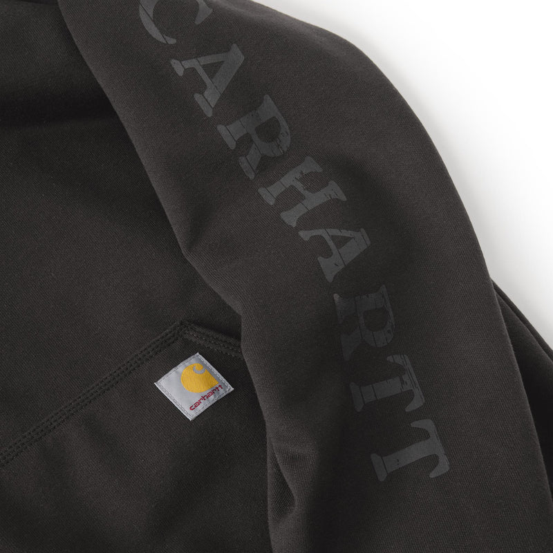 Load image into Gallery viewer, Close-up of a dark charcoal gray Carhartt hoodie showing the large 'CARHART' logo printed vertically on the sleeve and the signature Carhartt brand patch on the pocket.
