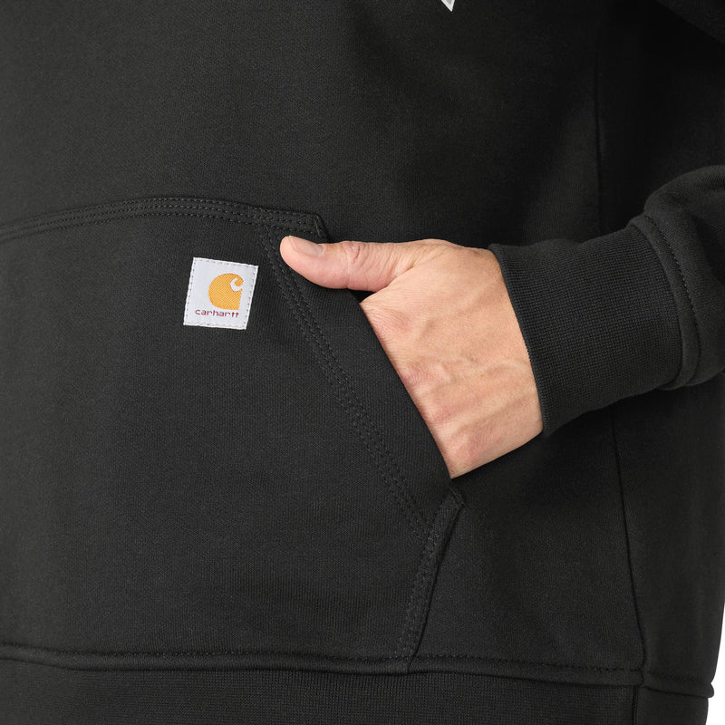 Load image into Gallery viewer, Close-up of a person wearing a black Carhartt hoodie, showing a hand in the front pocket with the brand's signature square patch visible.
