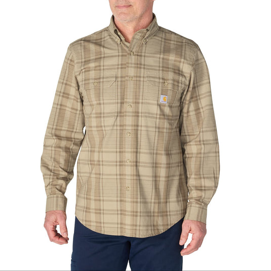 A man wearing a Carhartt long-sleeve button-down plaid shirt in beige and brown tones, paired with navy pants, against a plain white background.