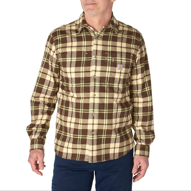 Load image into Gallery viewer, A man wearing a brown and beige plaid long-sleeve button-up shirt with a small Carhartt logo on the chest pocket, paired with navy pants, against a plain white background.
