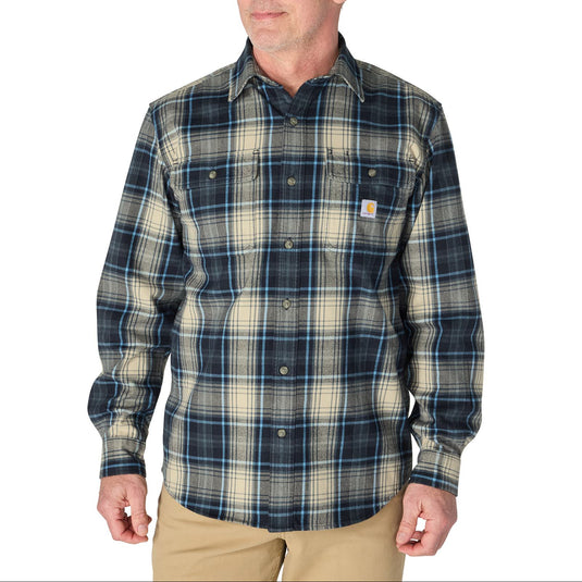 A man wearing a Carhartt long-sleeve plaid button-up shirt in navy, beige, and gray, paired with khaki pants, against a plain white background.