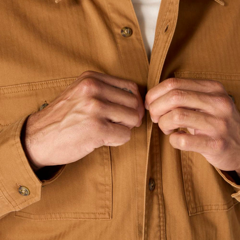 Load image into Gallery viewer, Close-up of hands buttoning a brown jacket
